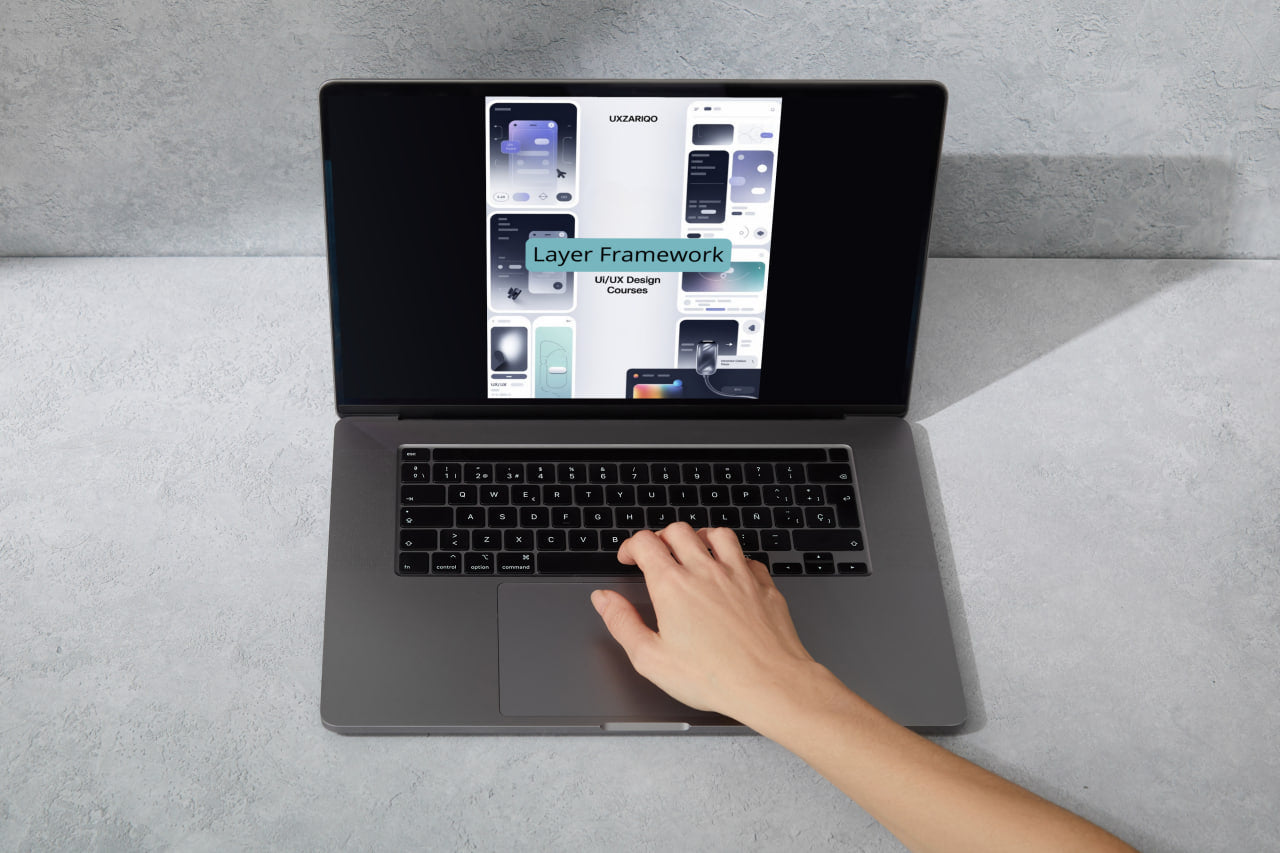 Person using a laptop on a gray surface